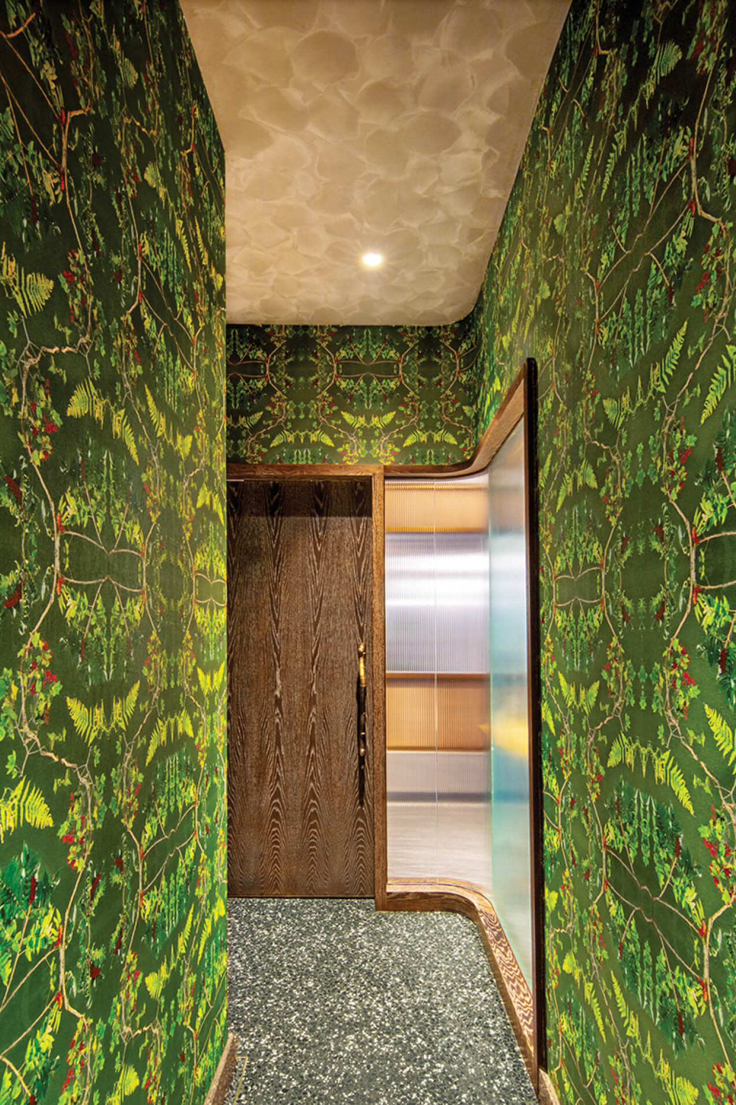 hallway to the restroom corridor with lots of green wallpaper resembling greenery