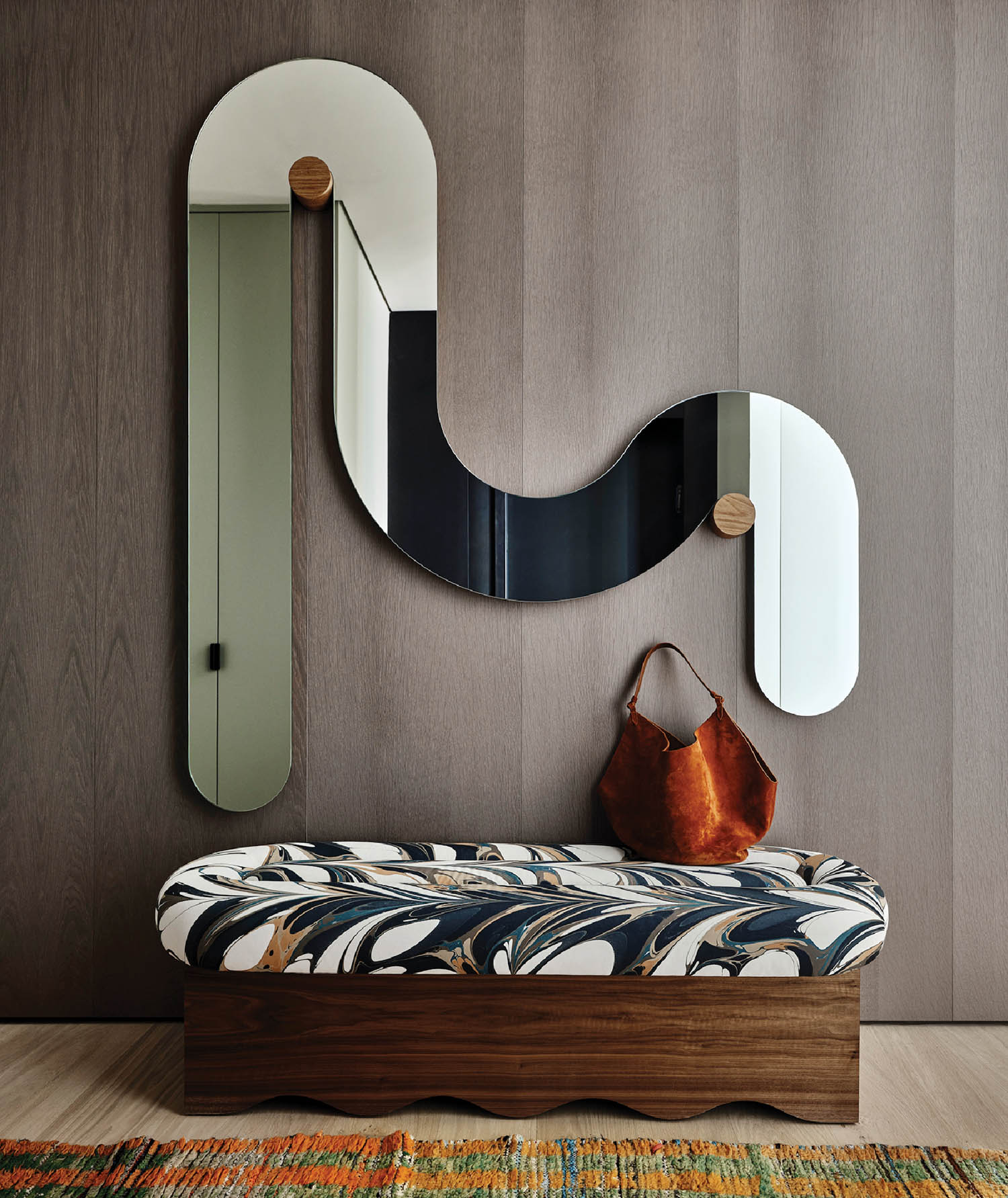 foyer with ripple curved mirror and bench with patterned cushion