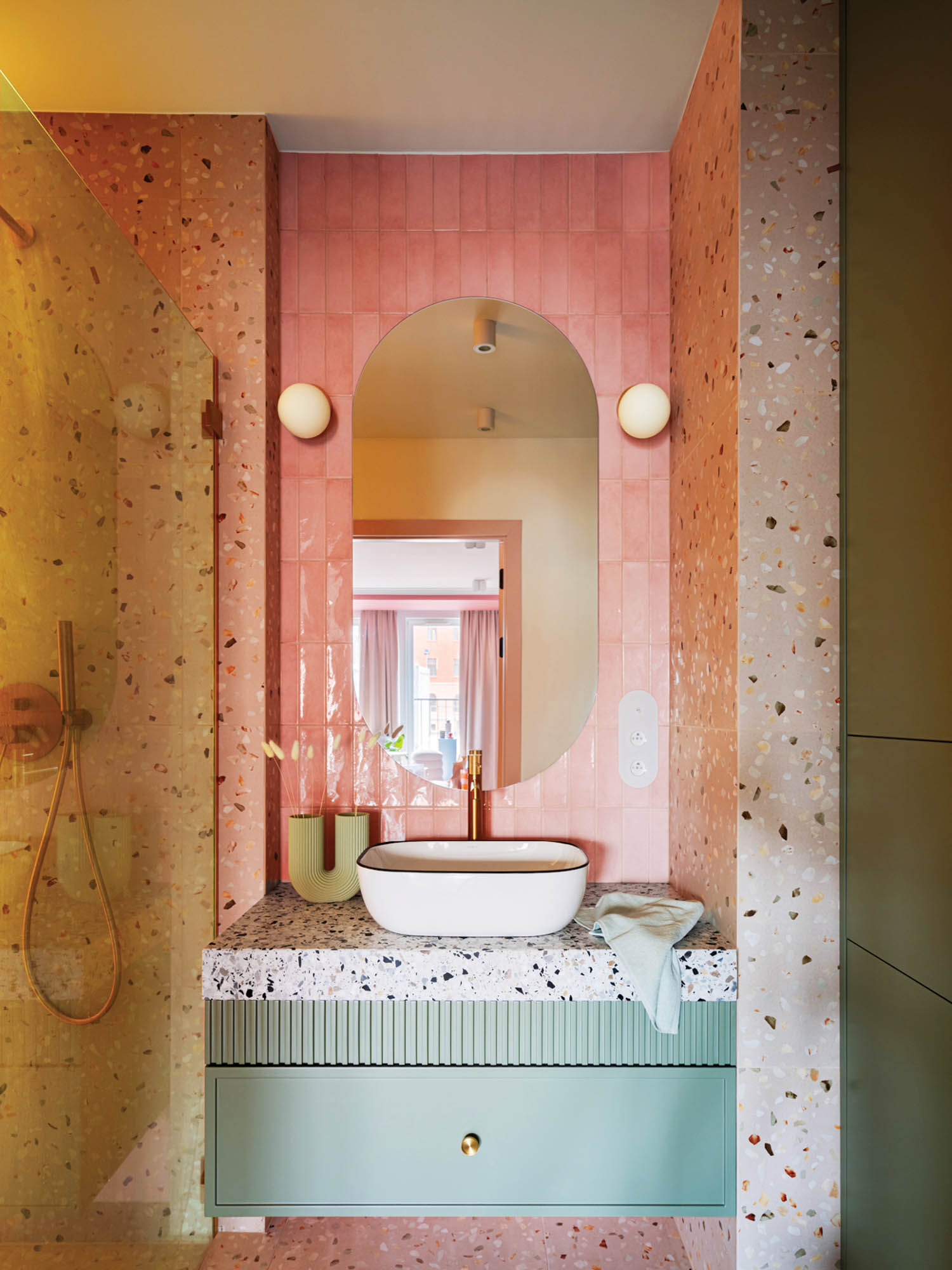 bathroom with pink tile, ovular mirror and blue vanity with marble topping