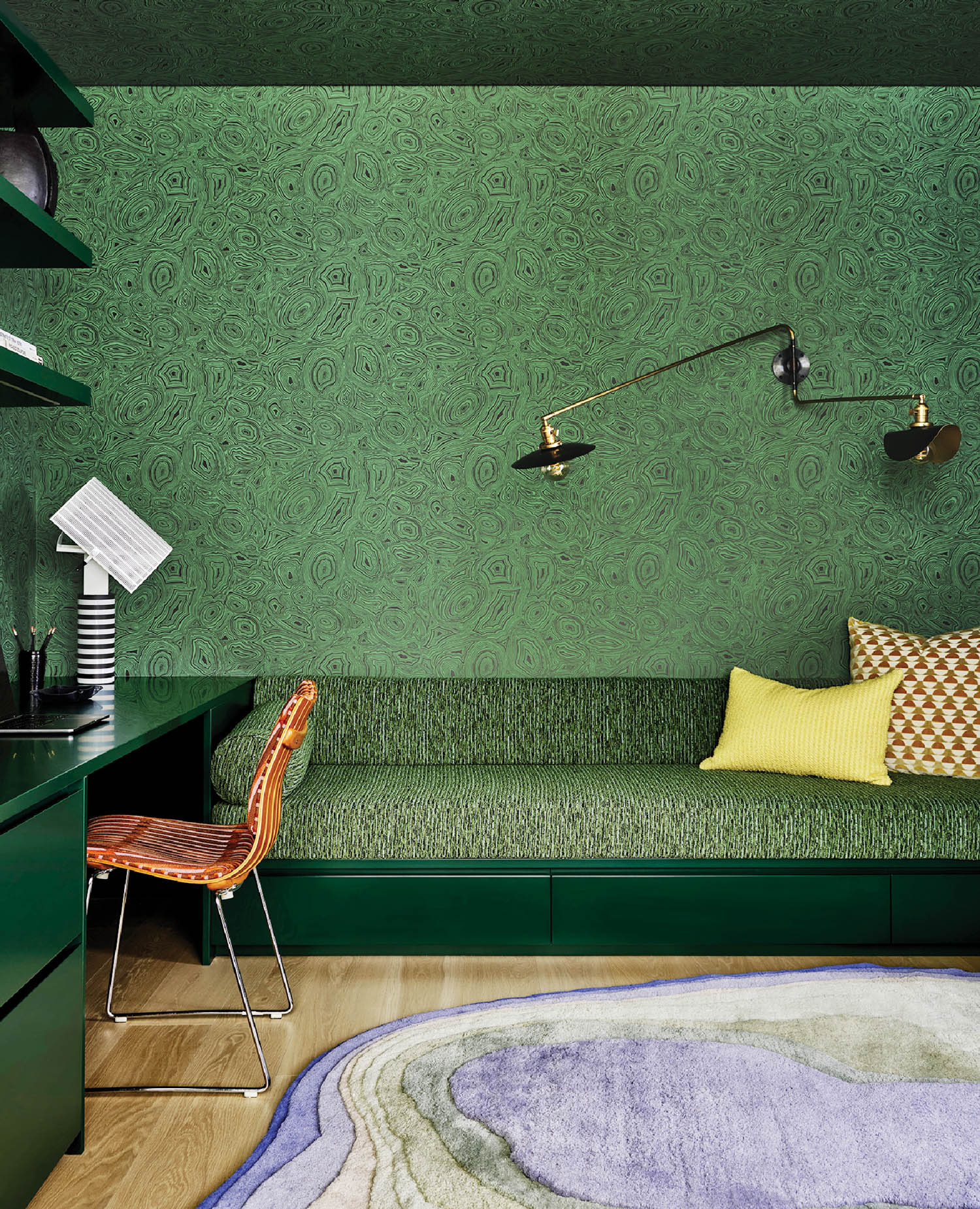 study area with green wallpaper and couch along with study area