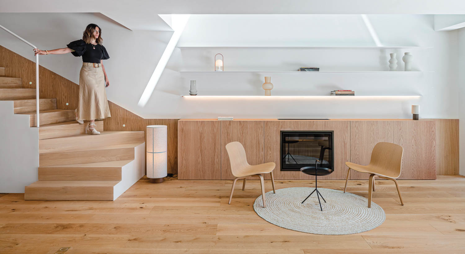 living area with two wooden chairs, wooden console and stairs