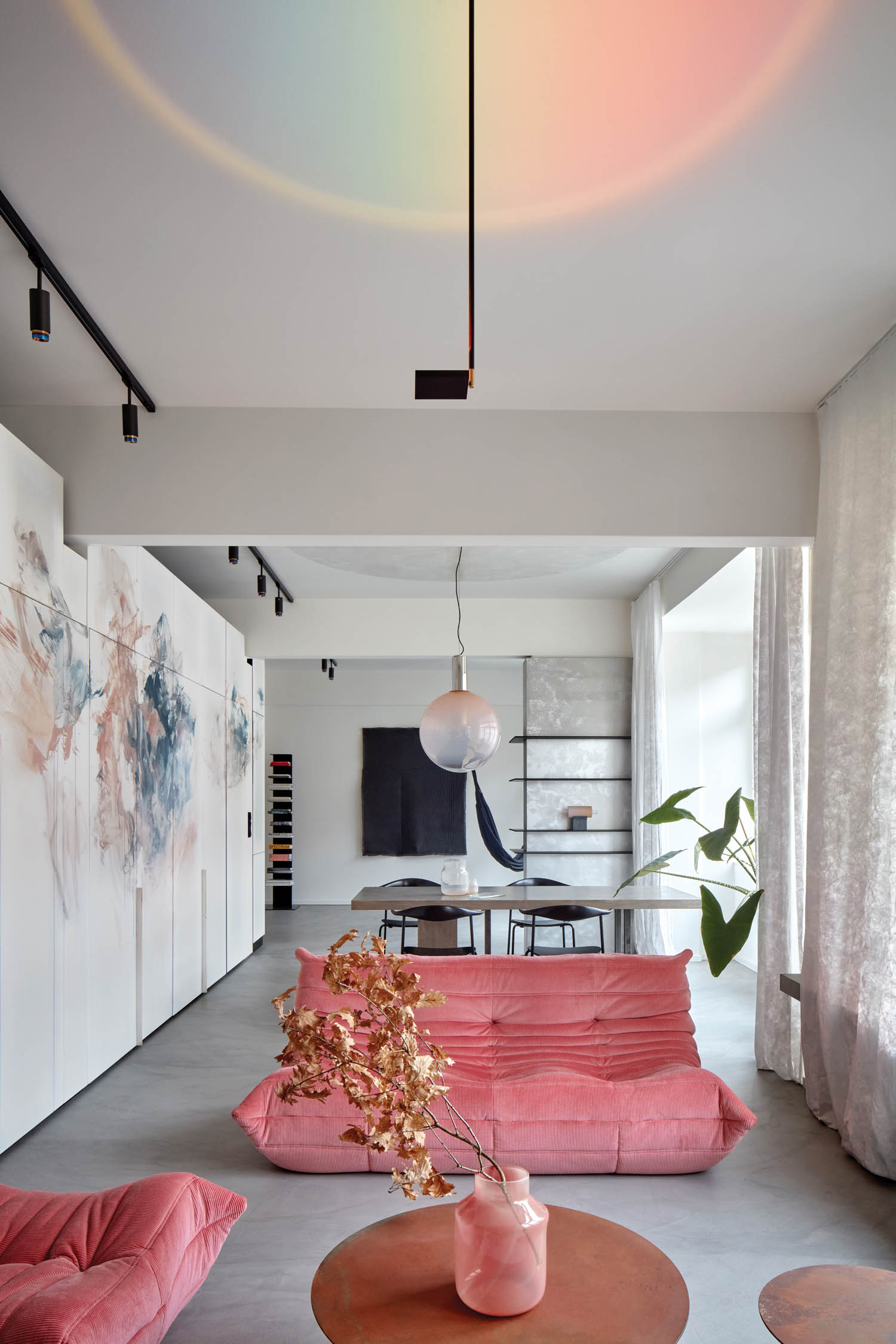 living area with bright pink couch and flowers on the wall