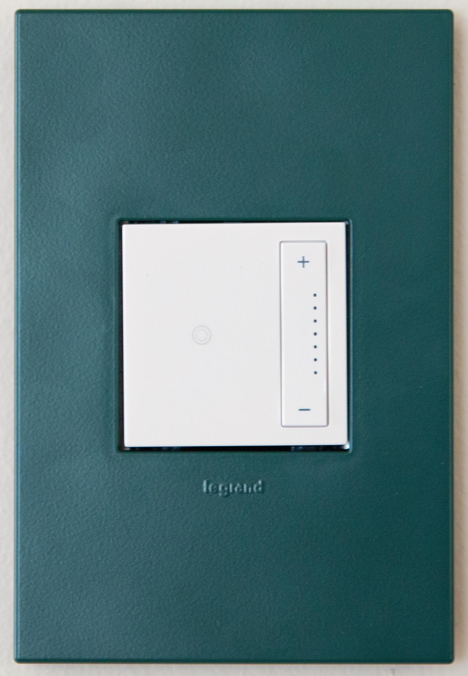 A light switch on a green wall