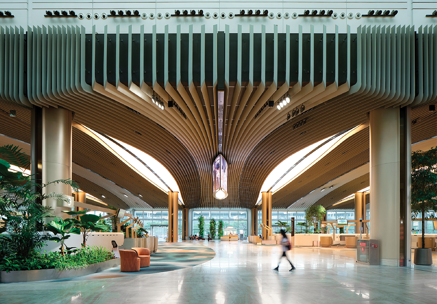 A large building with a long ceiling and a person walking in the