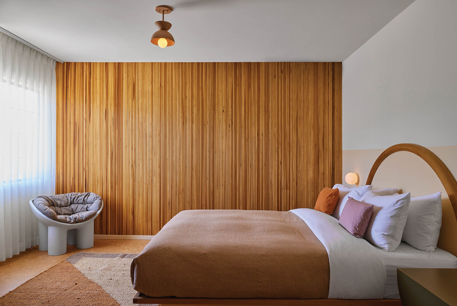 A bedroom with a bed and a chair