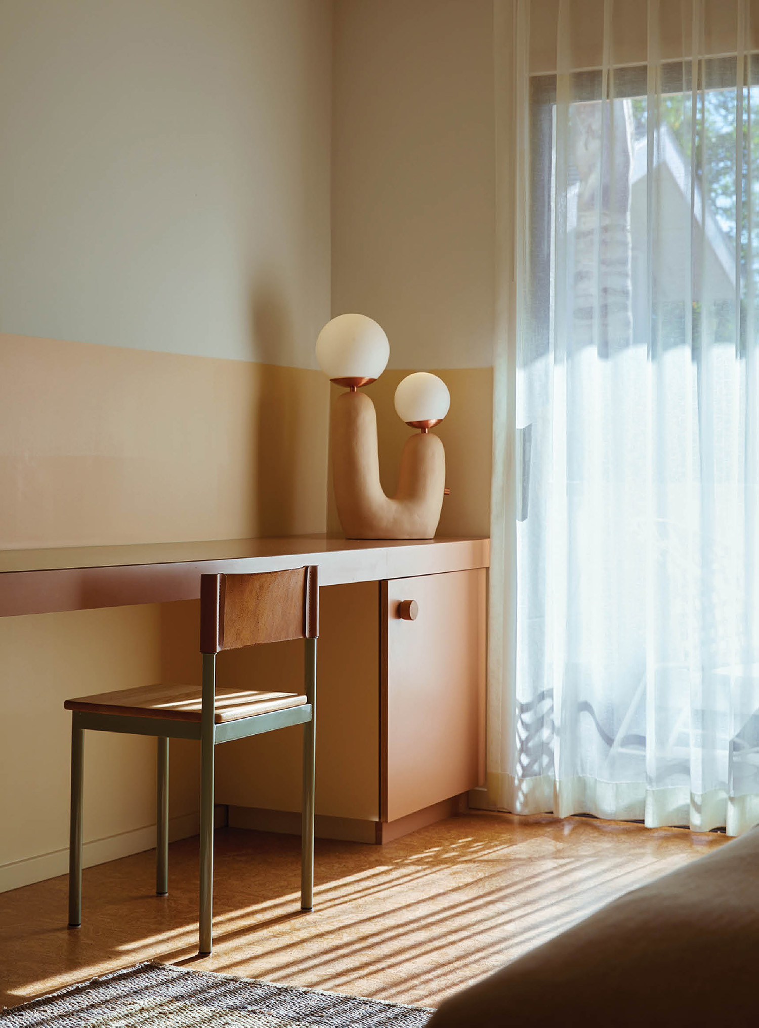 A bedroom with a bed, desk and a window