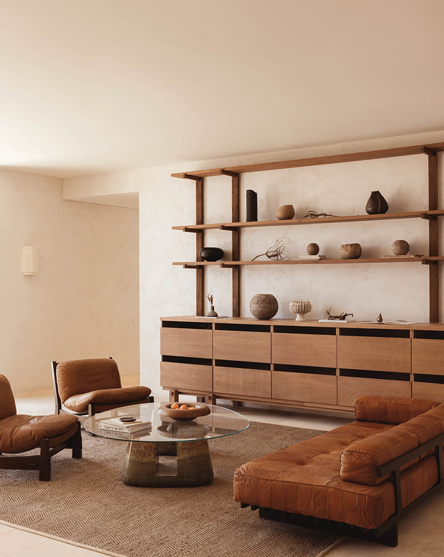 A living room with a couch, coffee table, and shelves