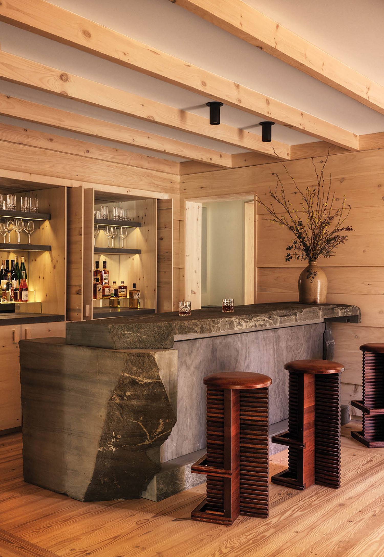 A bar with a large stone counter and stools