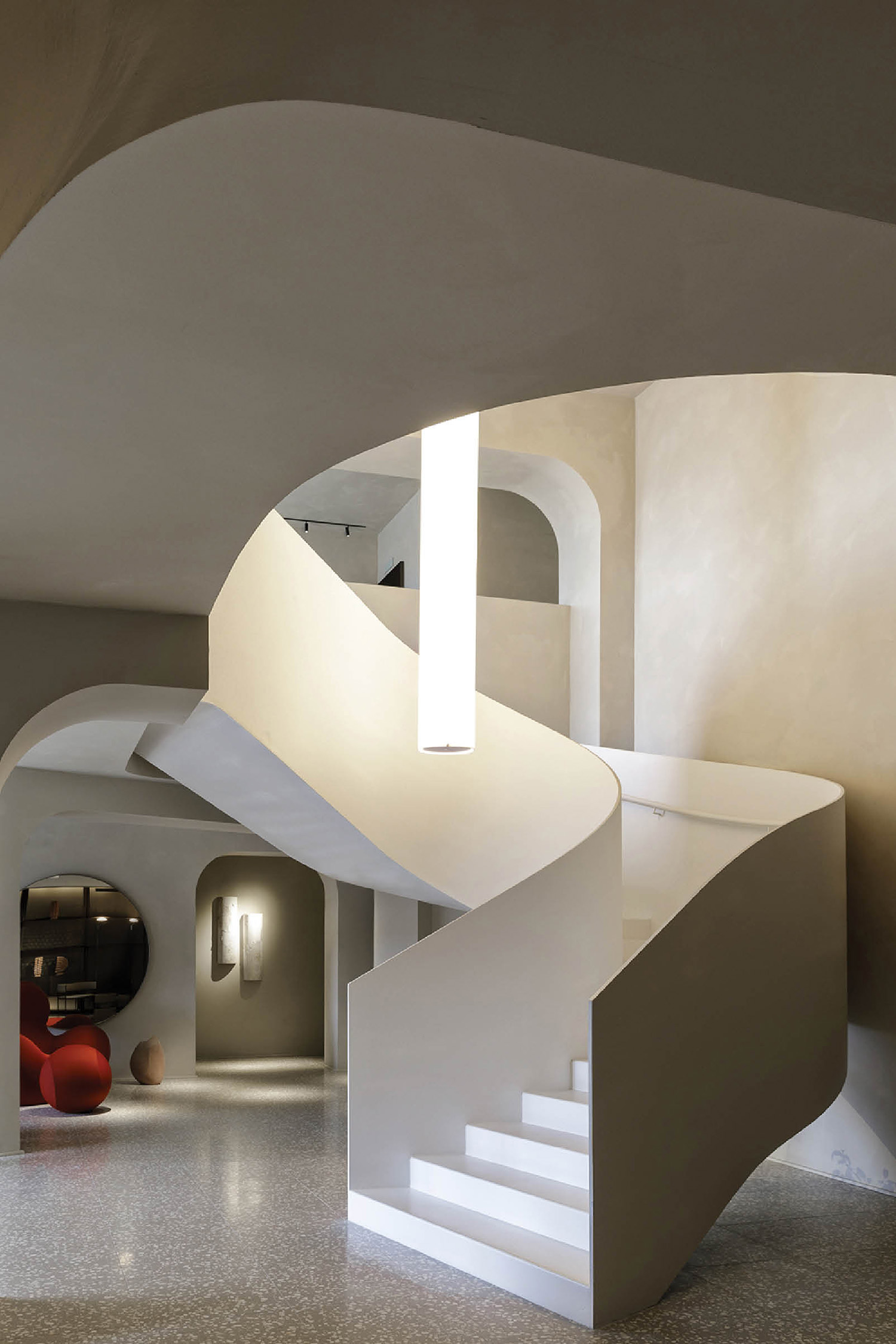 A white staircase with a red chair in the middle