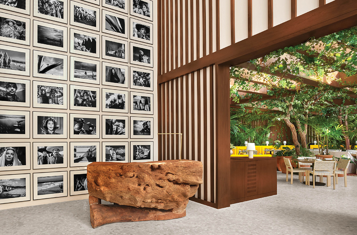 A room with a large wooden table and a wall of pictures