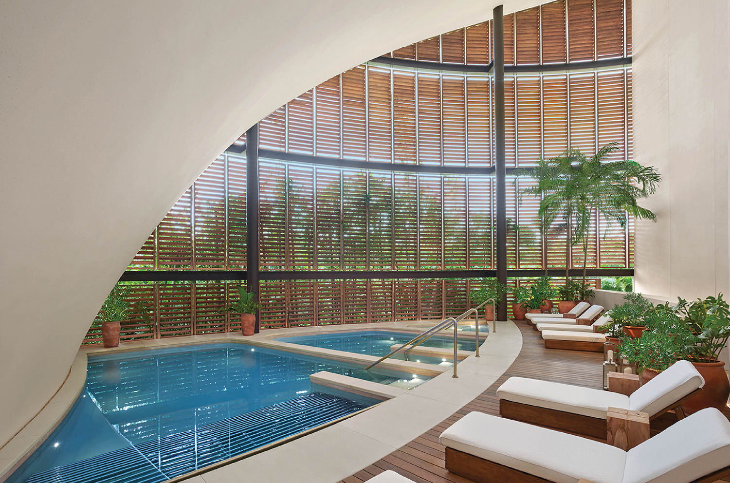 A pool with a wooden deck and a white couch