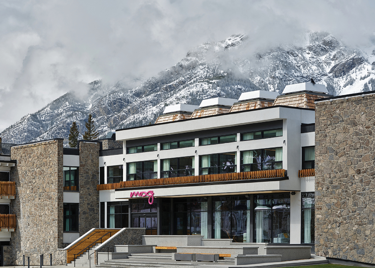 A large white ski chalet with a mountain in the background