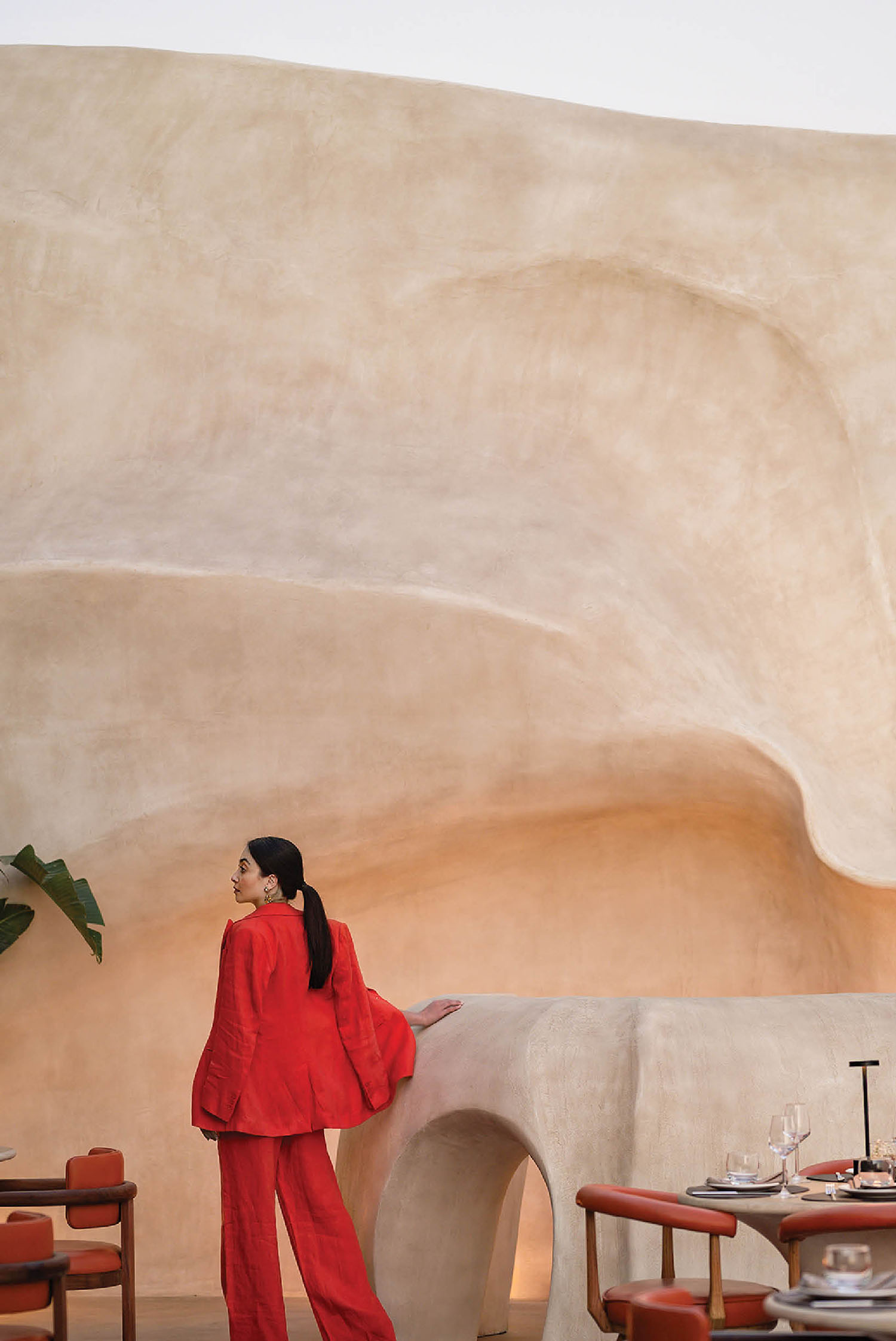 A woman in a red suit standing in a restaurant