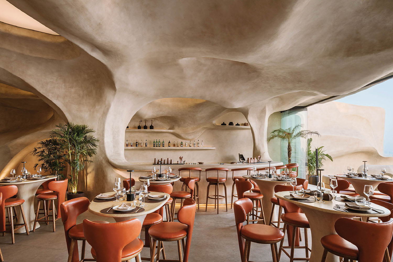 A restaurant with a large stone wall and a large ceiling