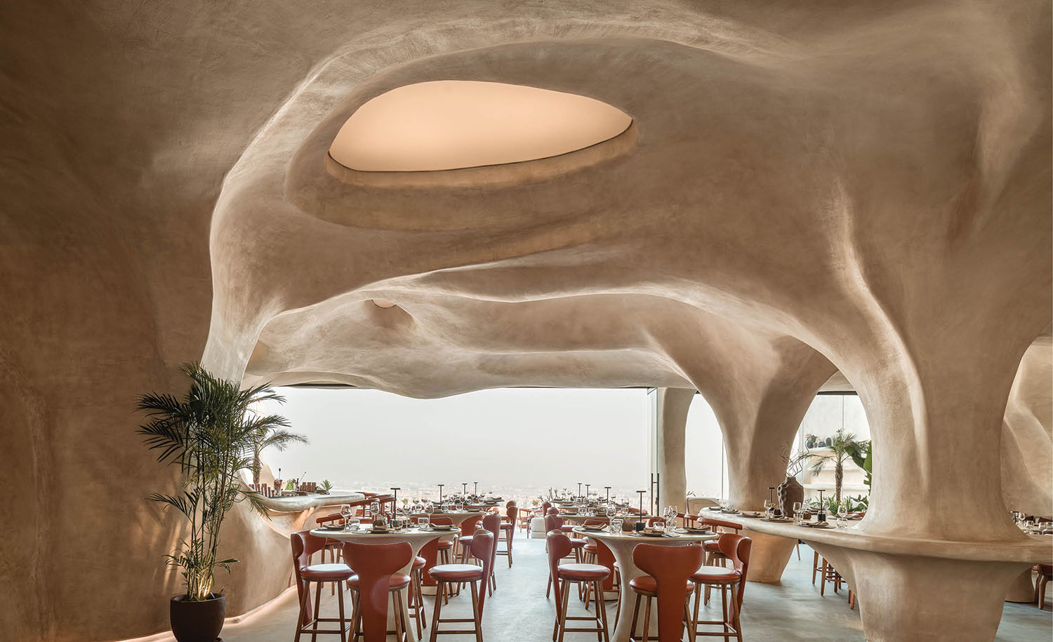 A restaurant with a large stone wall and a large ceiling