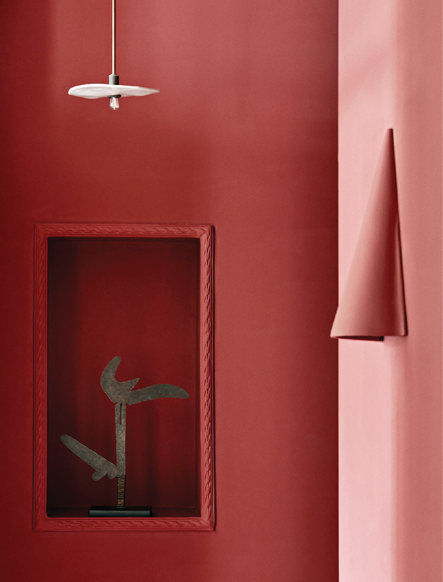 A red room with a mirror and a lamp