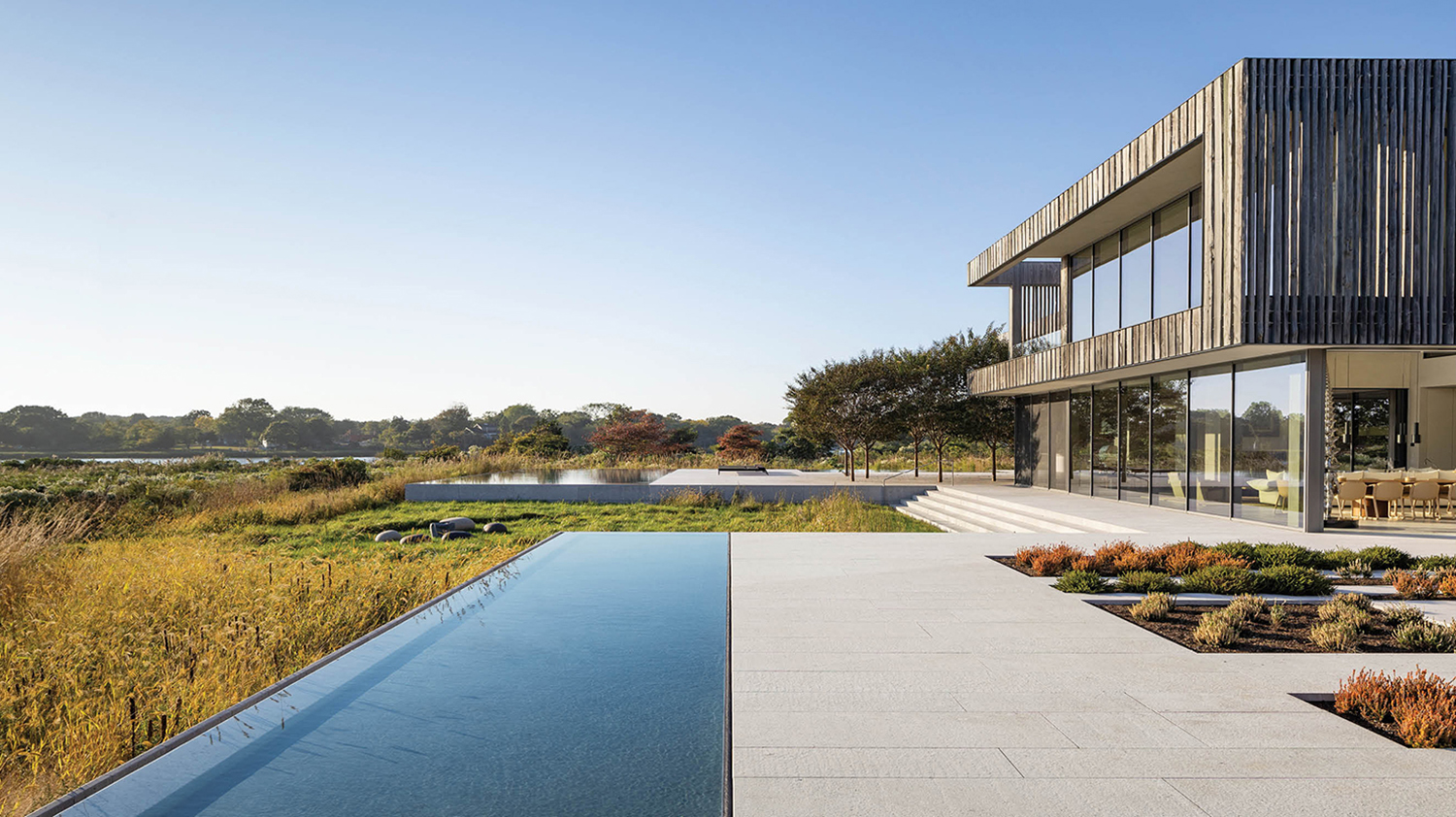 exterior facade of home with a pool and grassy field