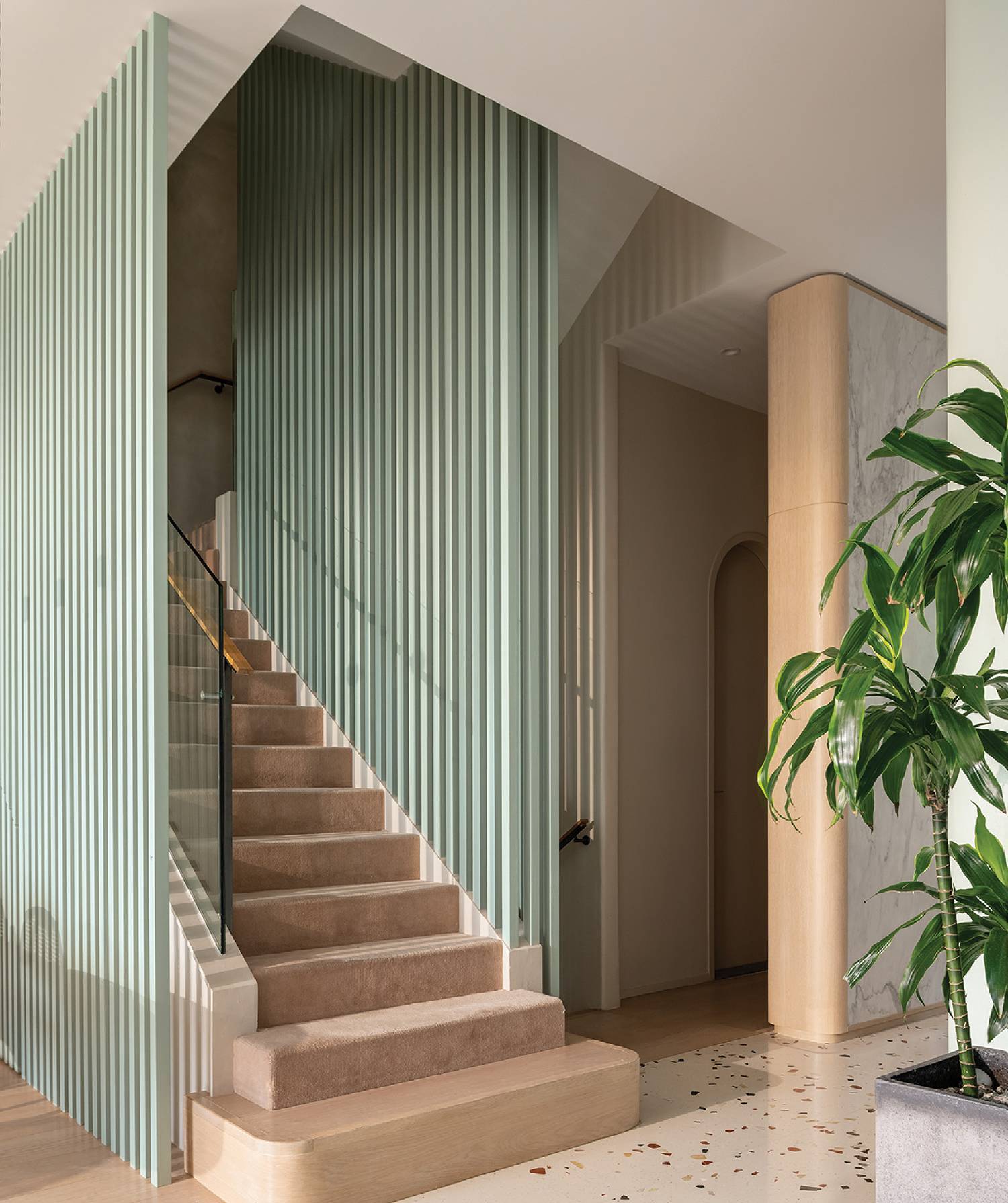 a staircase with a green striped wall and wooden steps