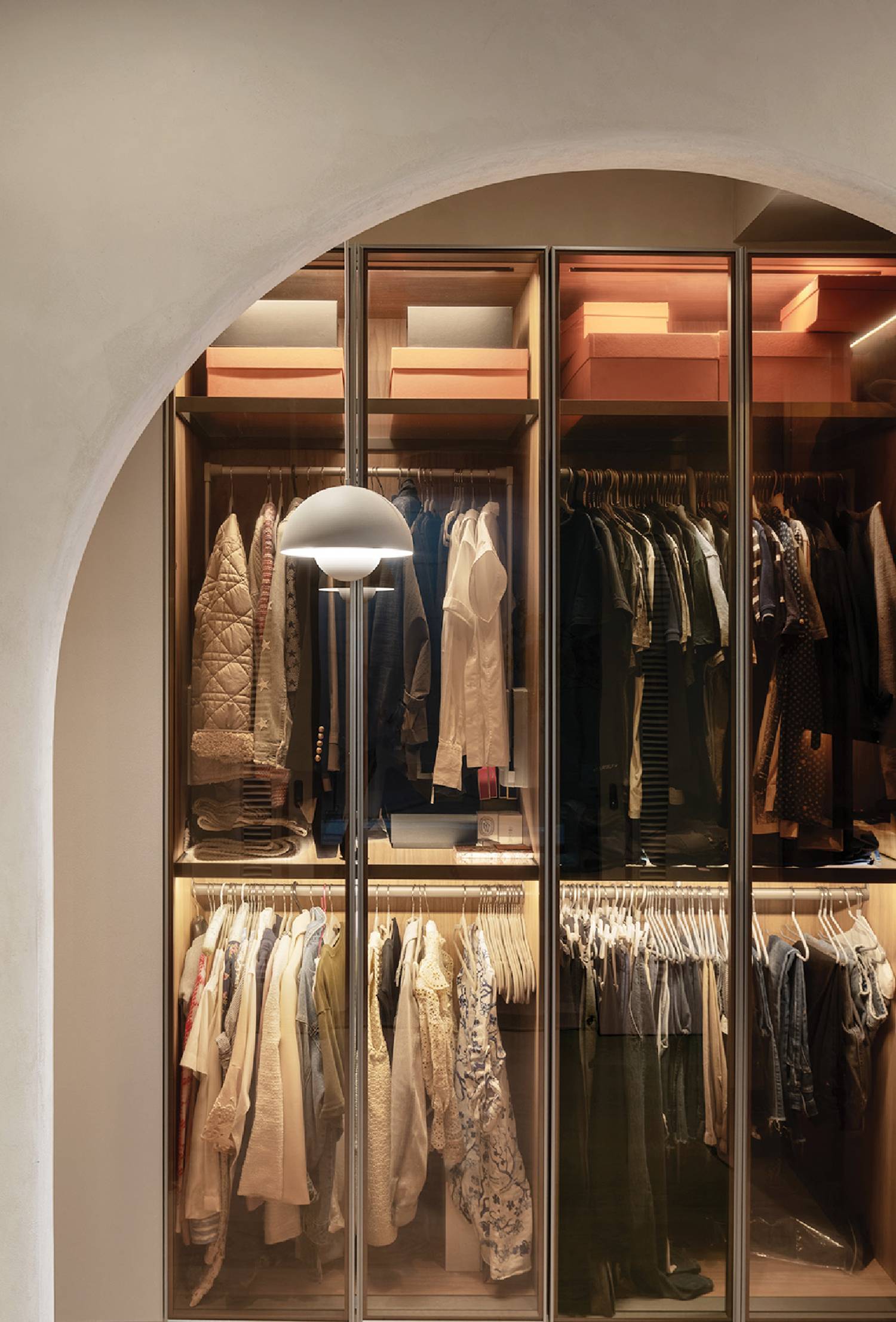 a closet with a lot of clothes hanging on the walls