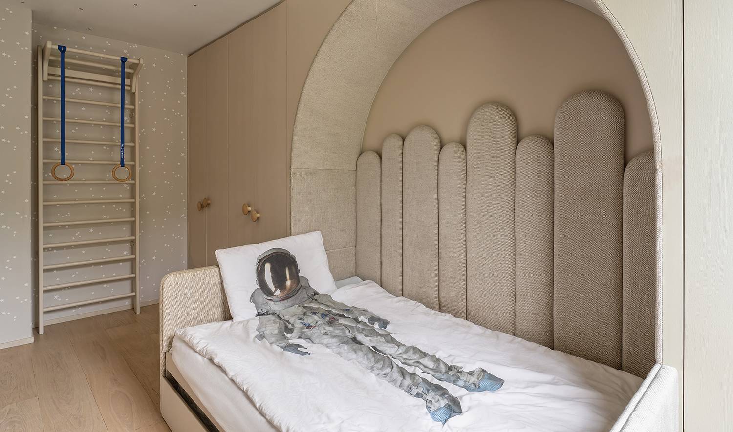 bedroom with white archway and bedsheet with astronaut