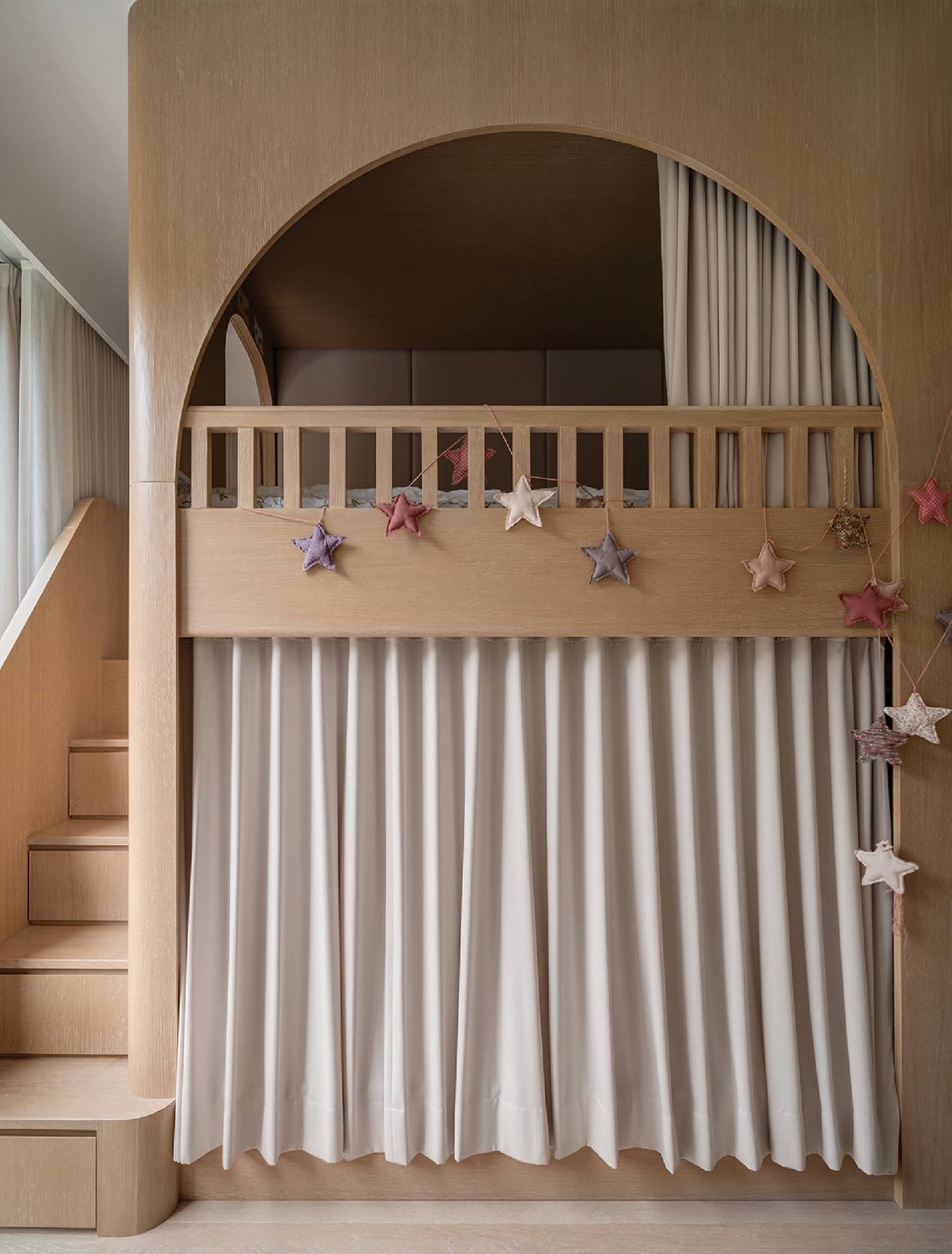 the entrance to a child's playroom with a balcony and drapes