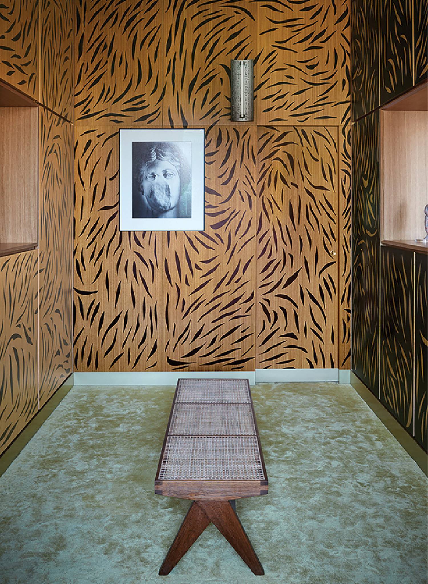 a room with a tiger print wallpaper and a wooden bench