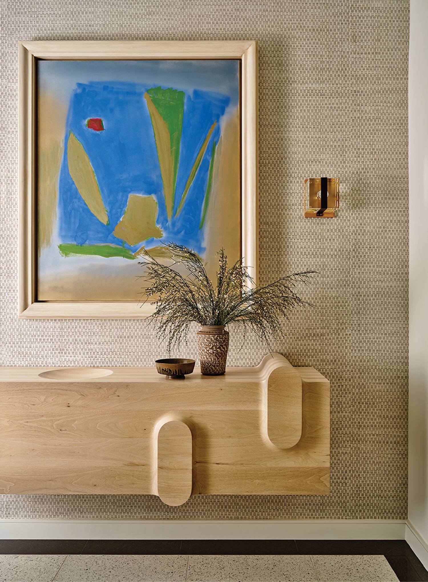 A painting on a wall above a wooden console
