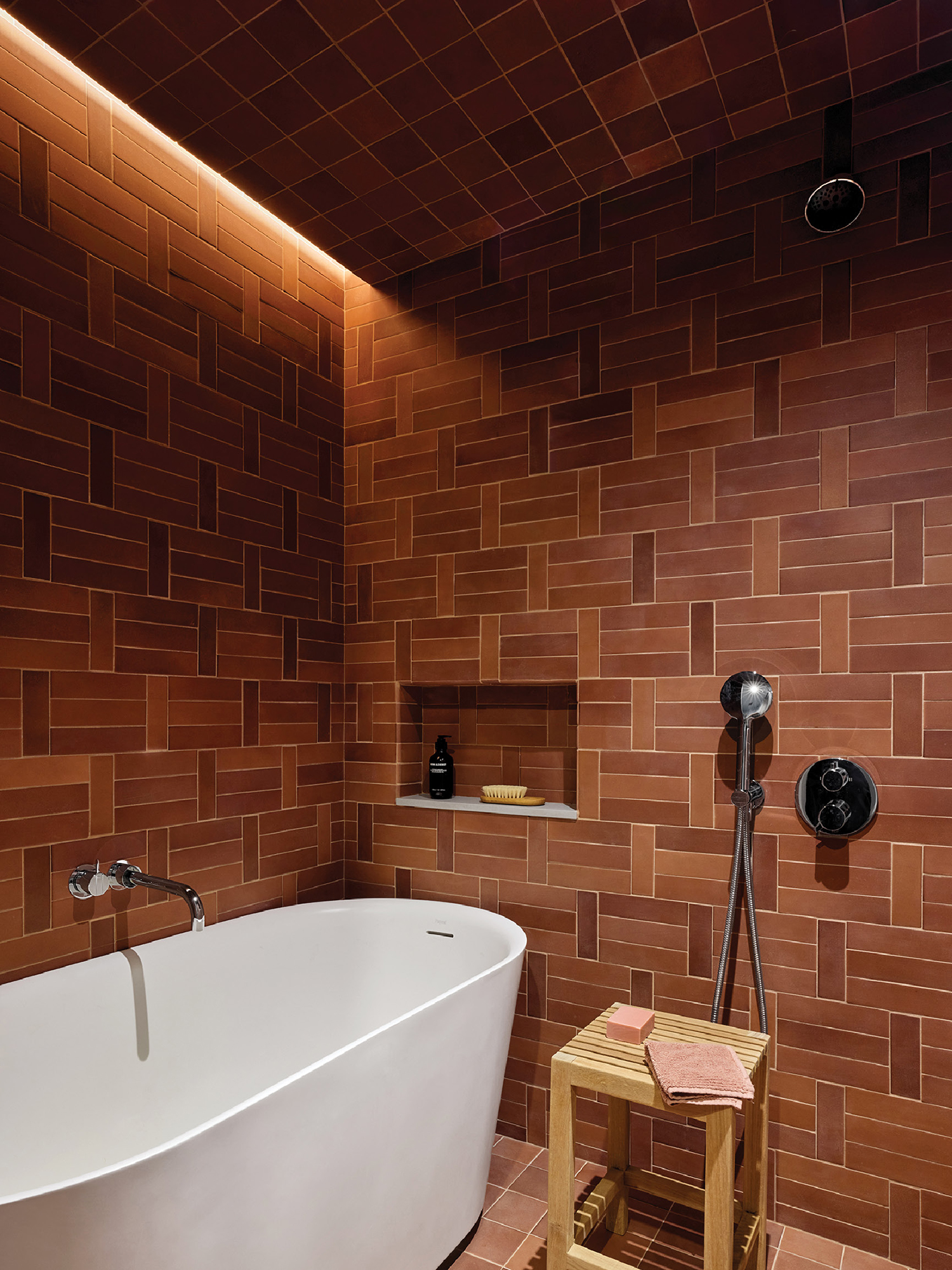 A bathtub in a bathroom with a wooden stool