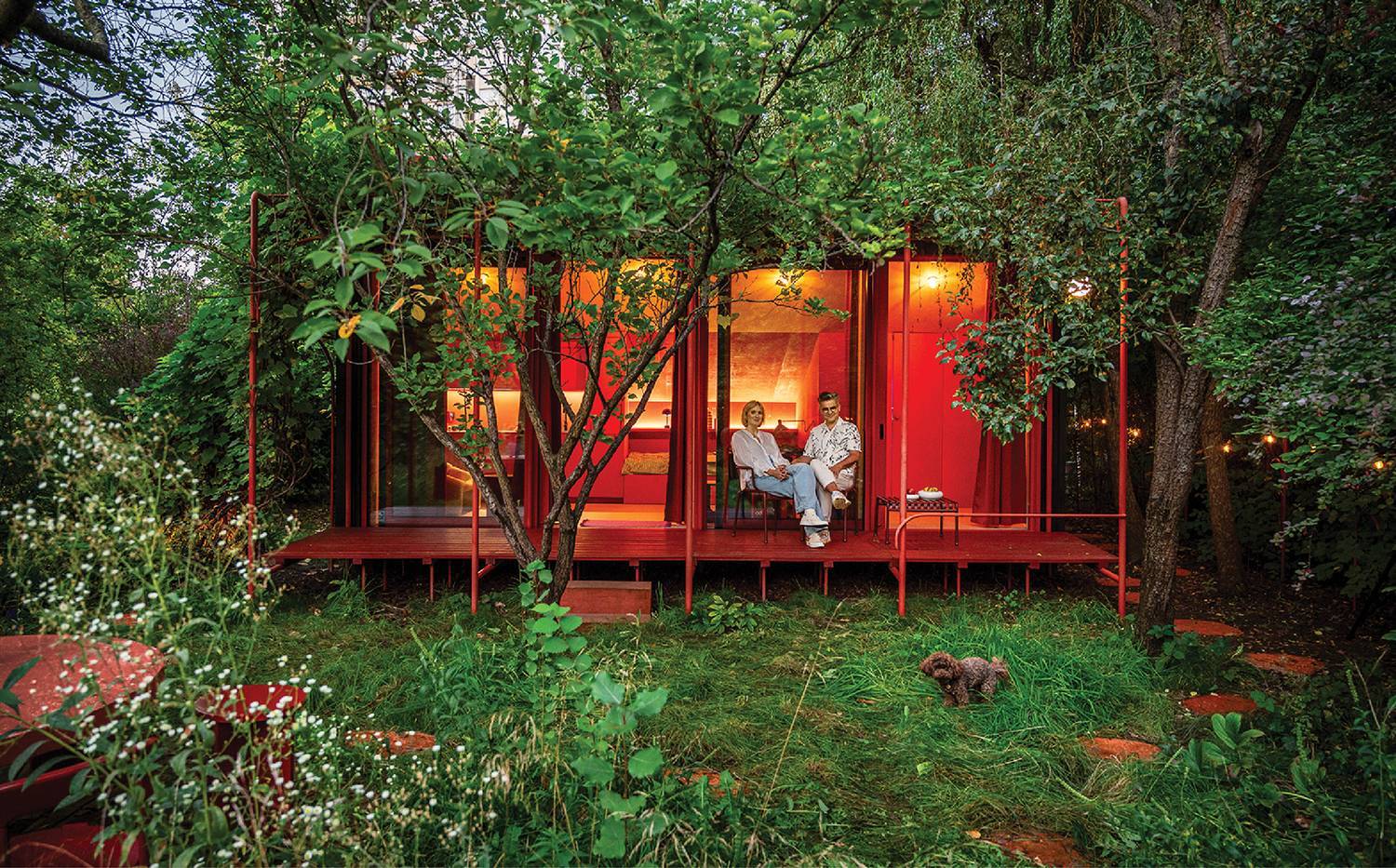 a woman sitting on a red deck in the woods