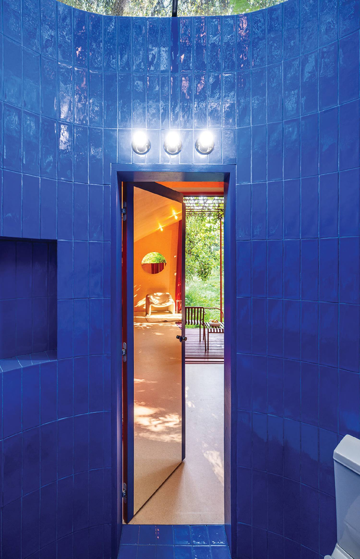 a bathroom with a blue tiled wall and a toilet