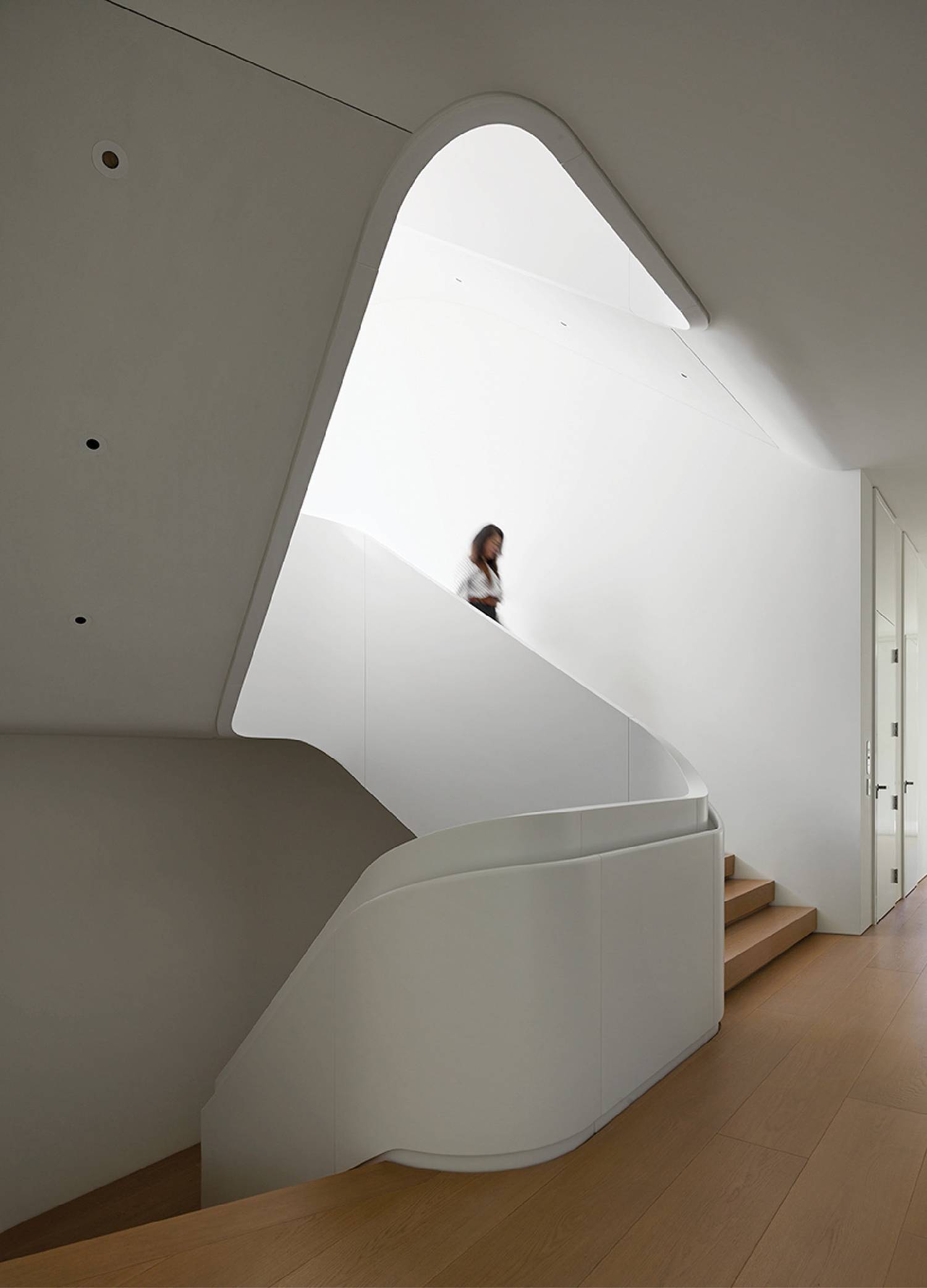 a white staircase with a curved window above it