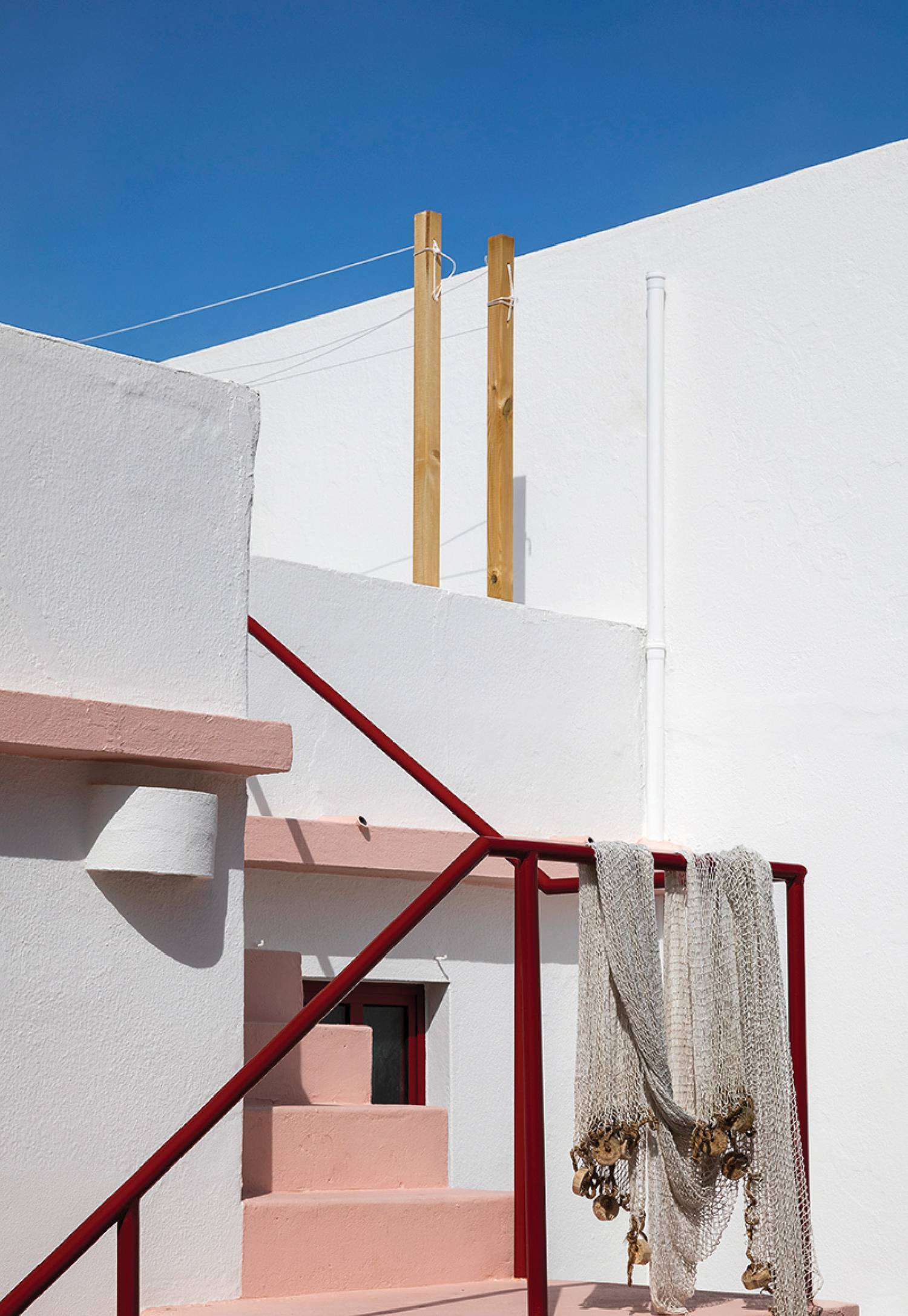 a white building with a red railing and a white wall