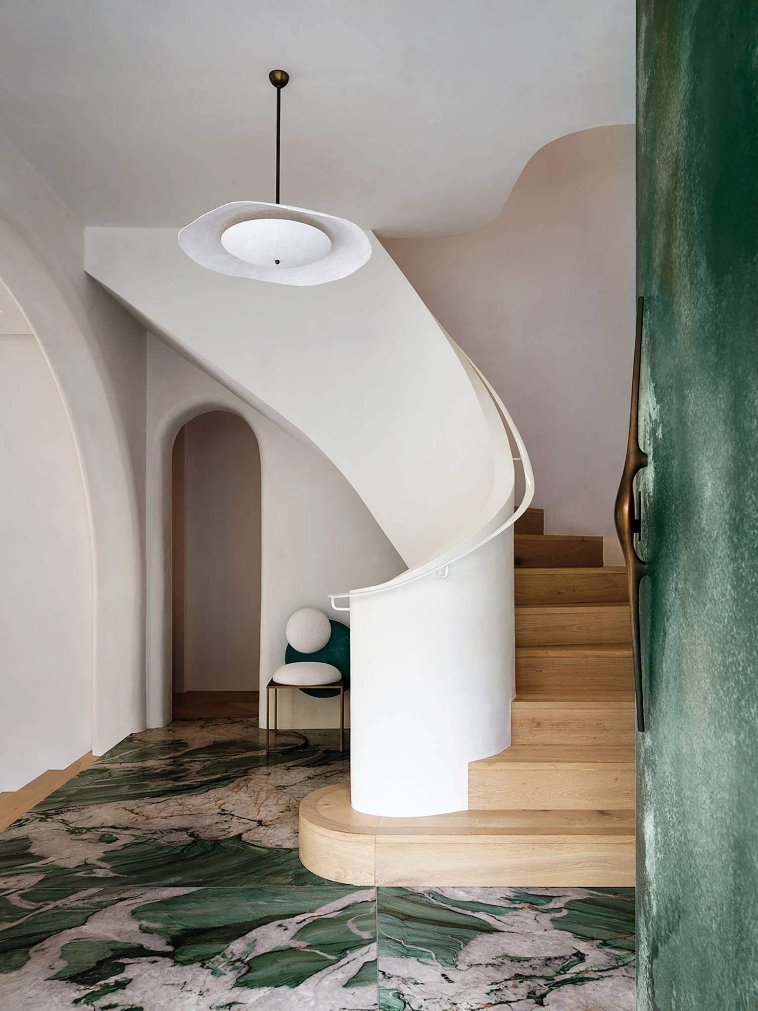 a spiral staircase with a green and white marble floor