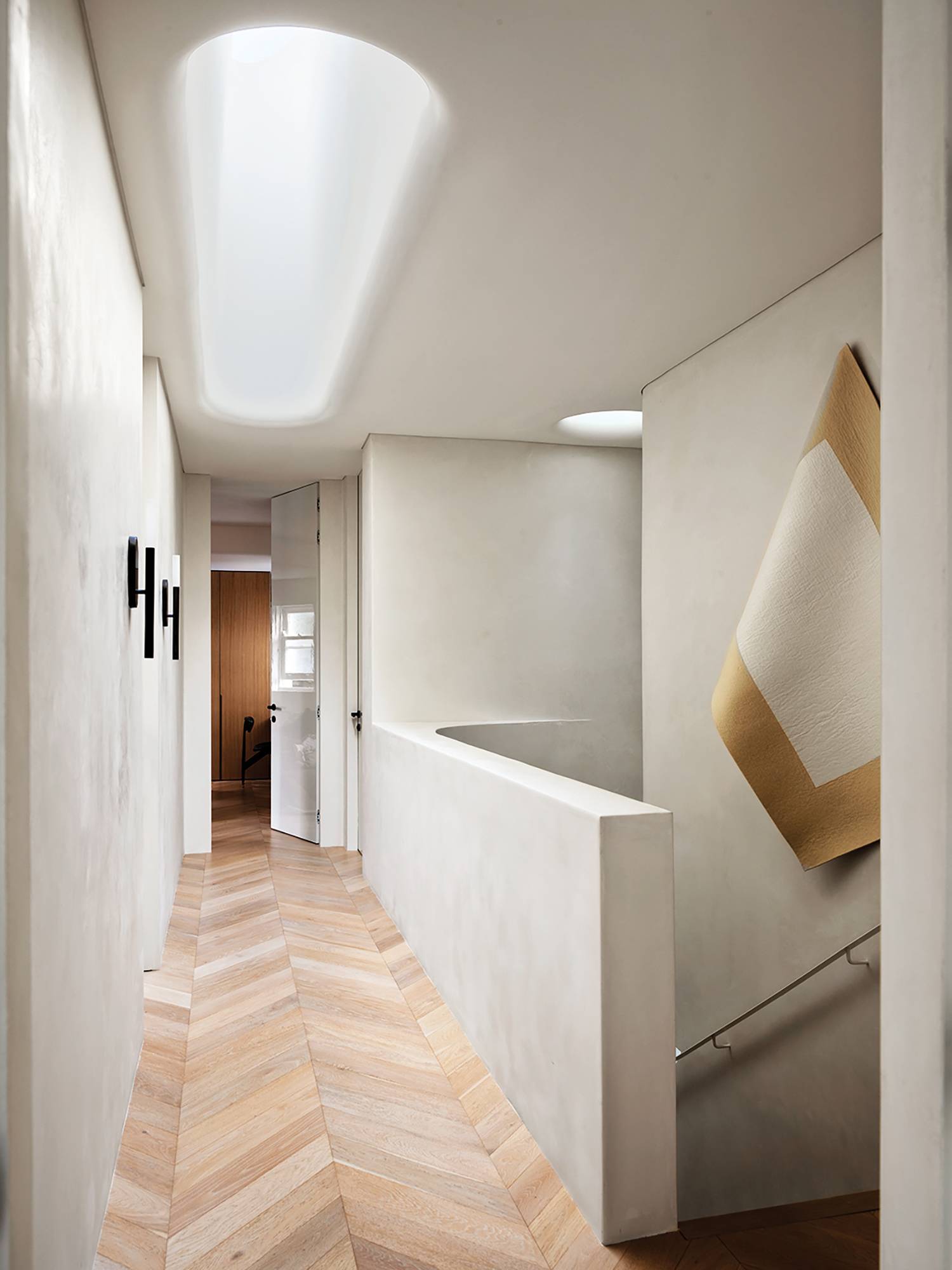 a long hallway with a wooden floor and a white wall