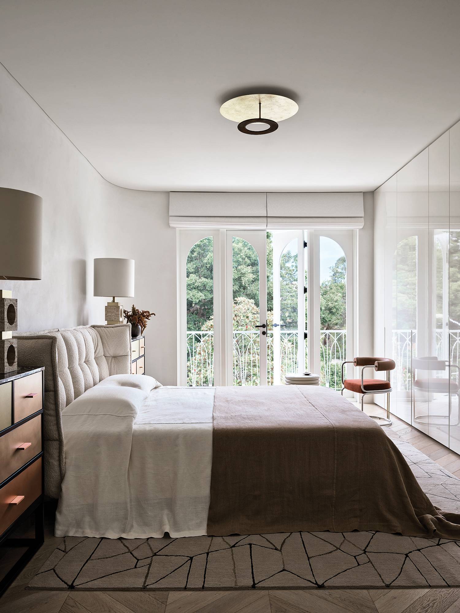 a bedroom with a bed and a large window in home by Greg Natale