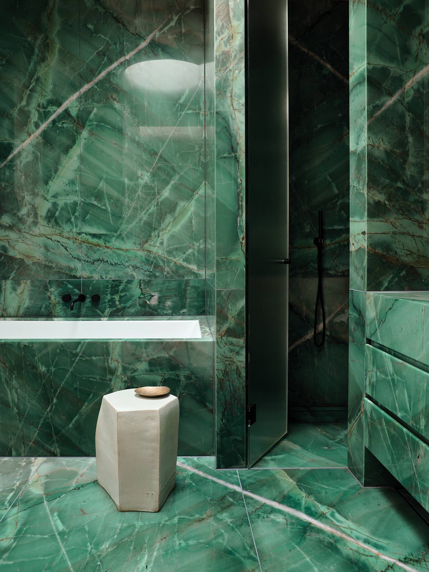 a bathroom with a marble floor and a tub