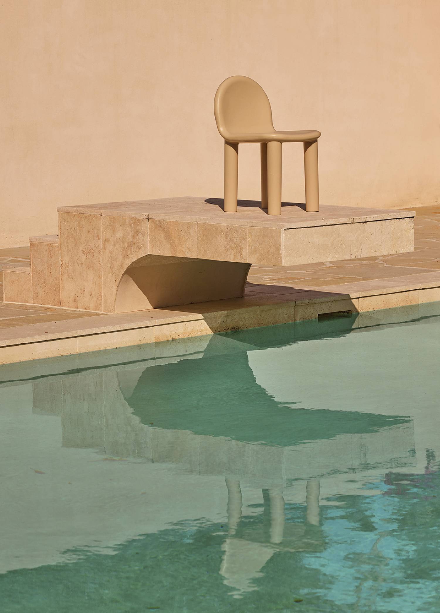 a chair sitting on the edge of a pool