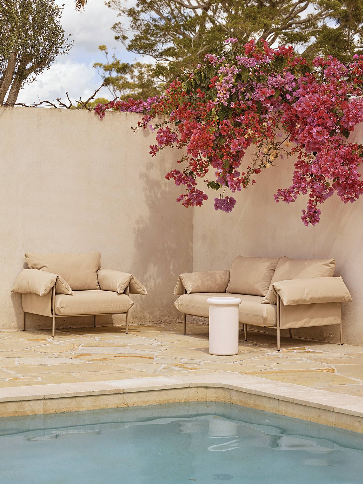 a pool with a tree and two chairs