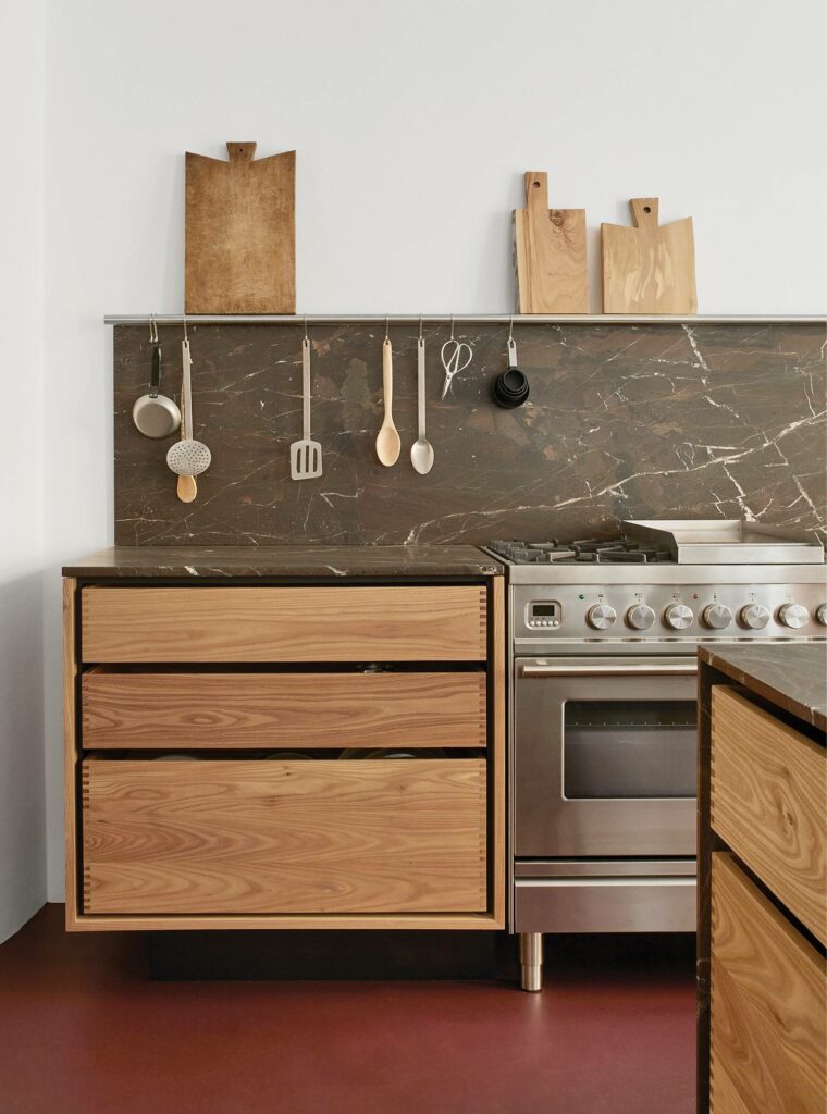 a kitchen with a stove, sink, and a counter