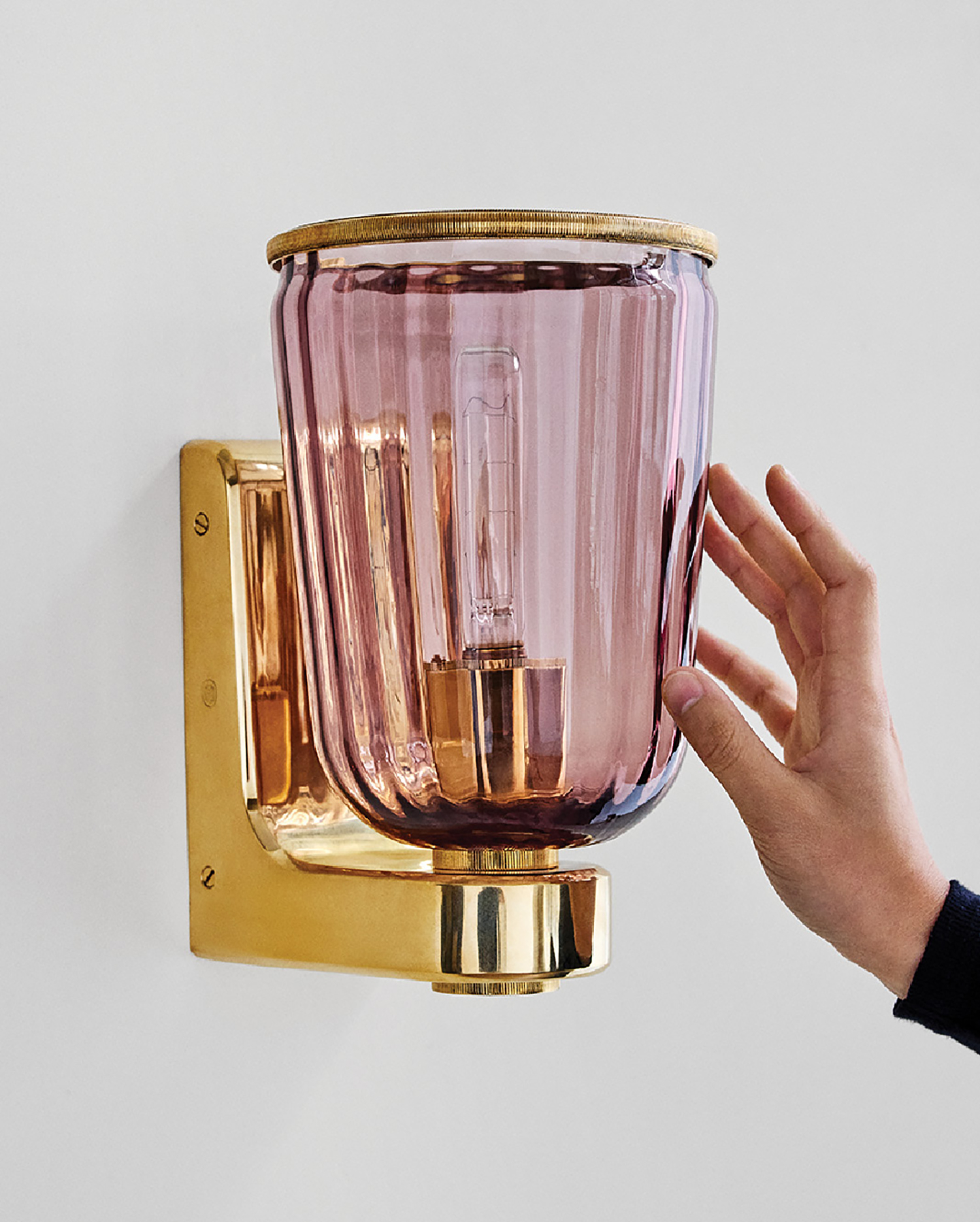 A person holding a pink glass light