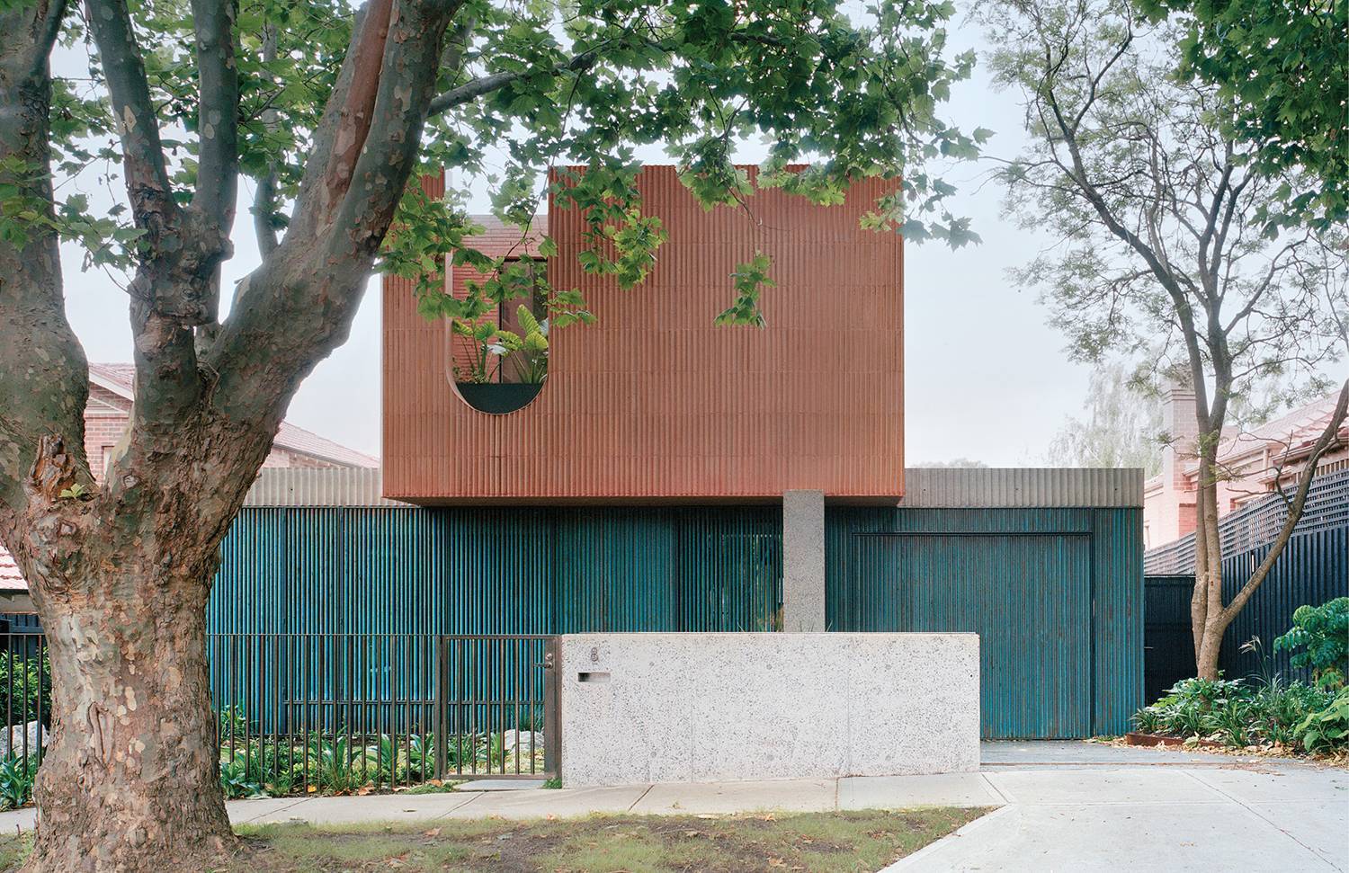 a house by Pandolfini Architects with a copper roof and a copper roof