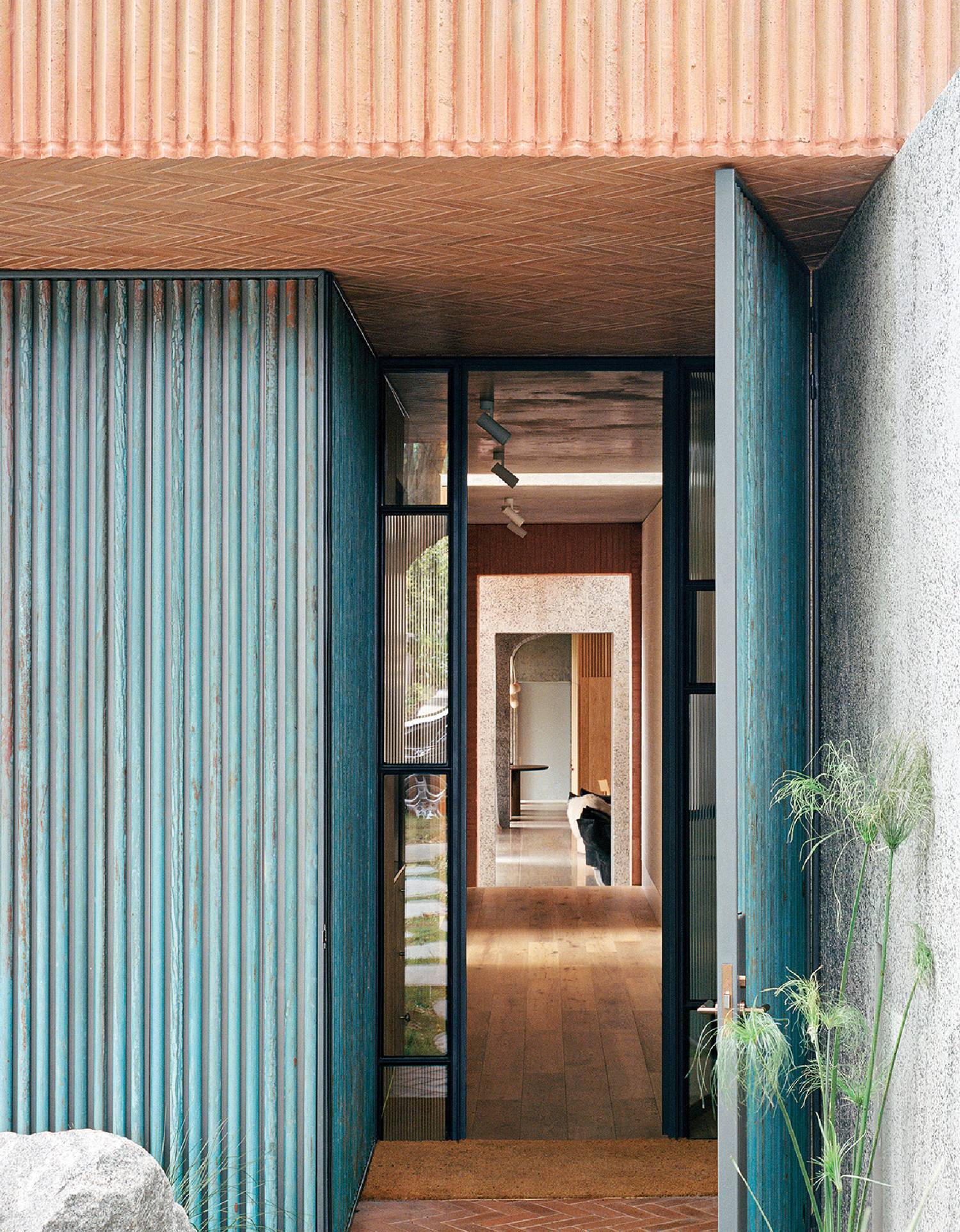 A blue container is in the middle of a hallway in home by Pandolfini Architects