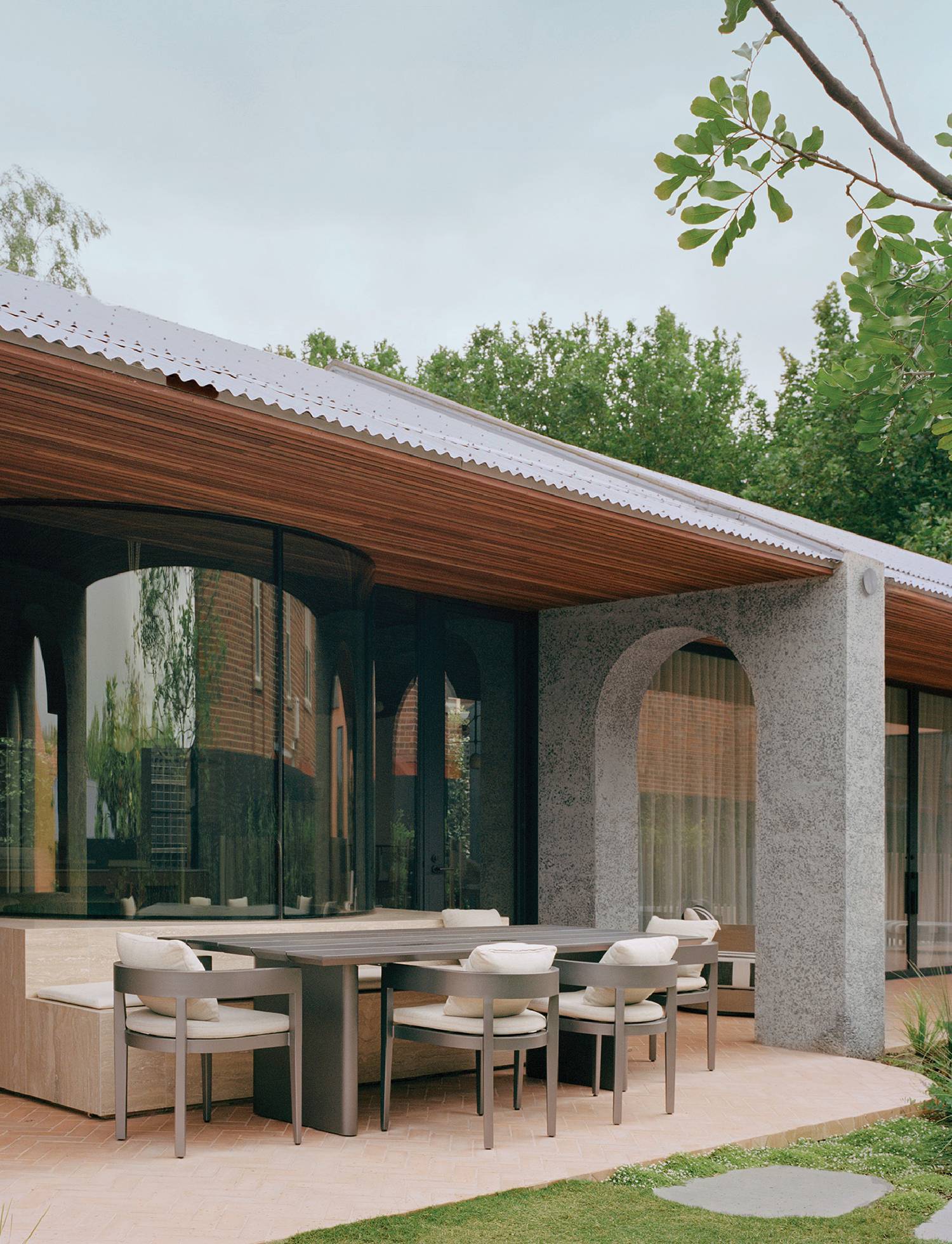 A patio with a table and chairs under a roof