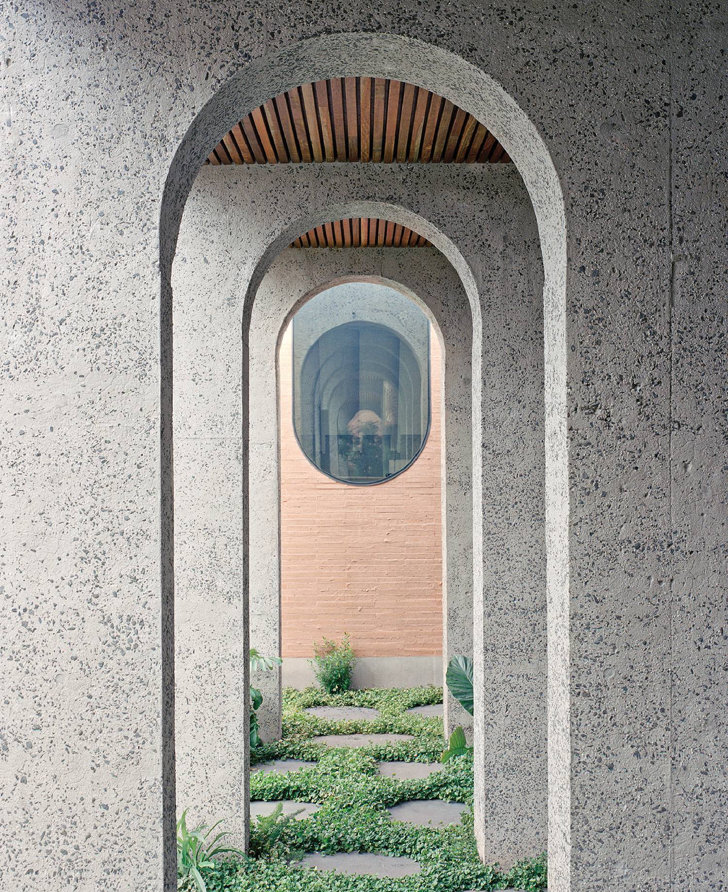 a stone walkway with a circular window in the middle