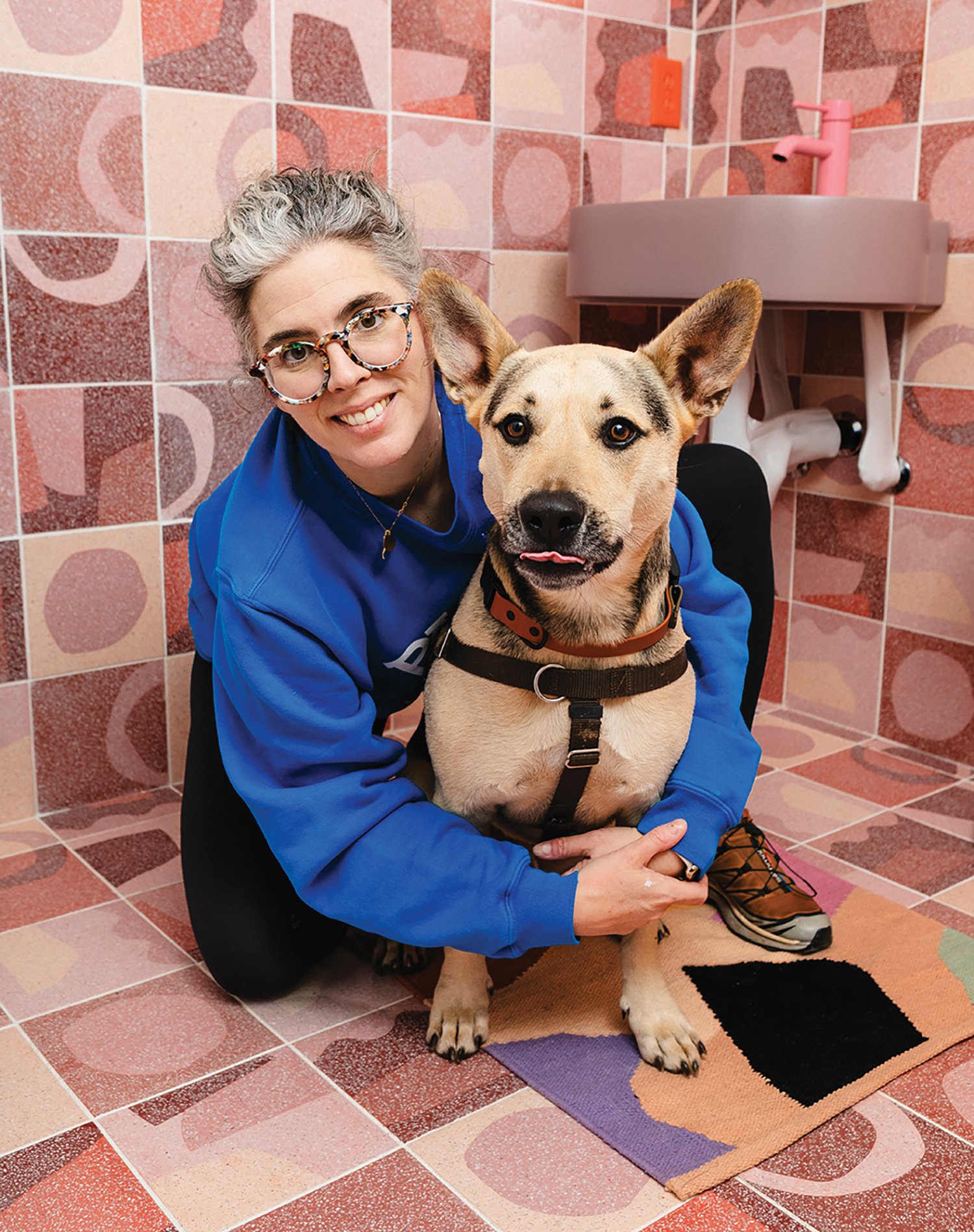 A woman sitting on the floor with a dog