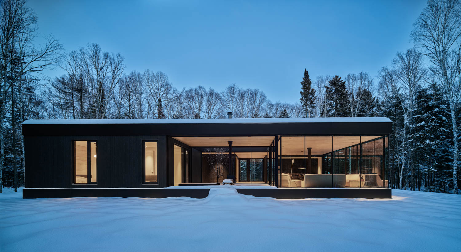 a ski chalet in Canada lit up at night atop a snowy landscape