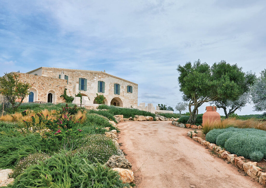 facade of blanc farmhouse menorca with dirt road