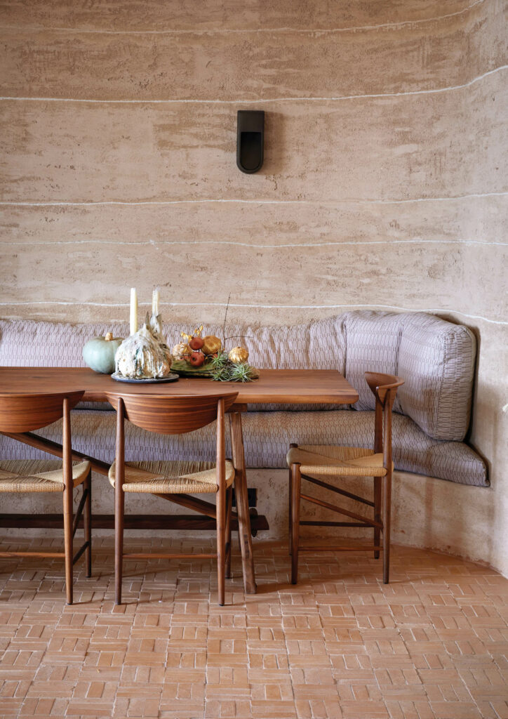 A built-in banquette forms a nook in the restaurant in the boyera, or barn, joined by Hvidt & Mølgaard’s Drawn chairs.