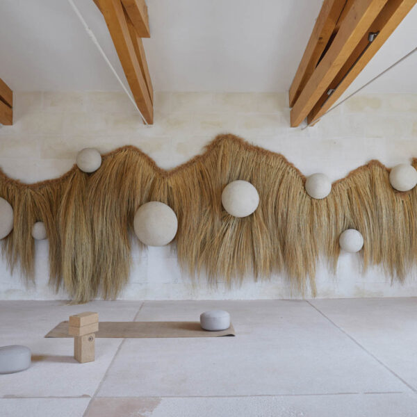 a yoga studio with wood beam ceilings and a wall installation