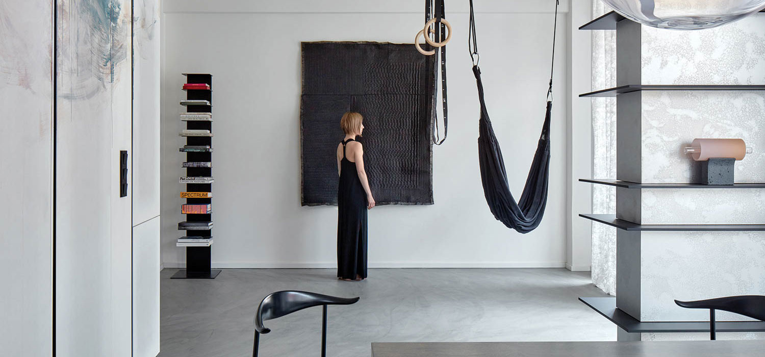 woman standing near a black hammock in a black dress